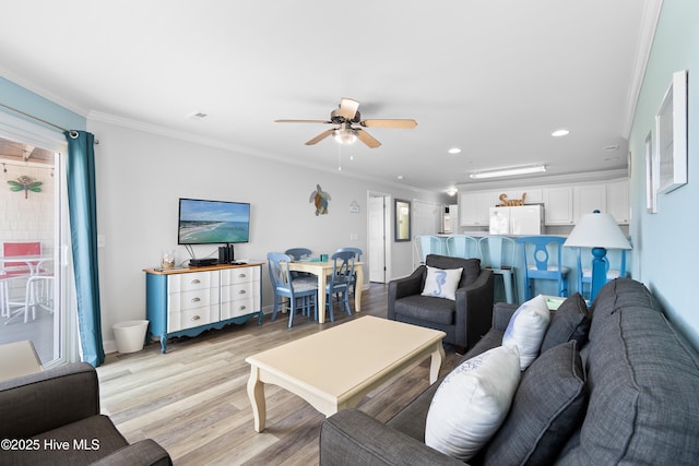 living room featuring ceiling fan, ornamental molding, and light hardwood / wood-style floors
