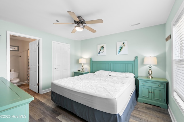 bedroom featuring dark hardwood / wood-style floors, ceiling fan, and ensuite bathroom