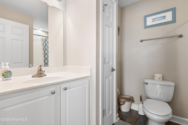 bathroom with vanity, hardwood / wood-style flooring, curtained shower, and toilet
