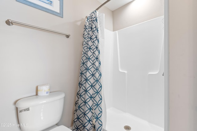 bathroom with a shower with curtain and toilet