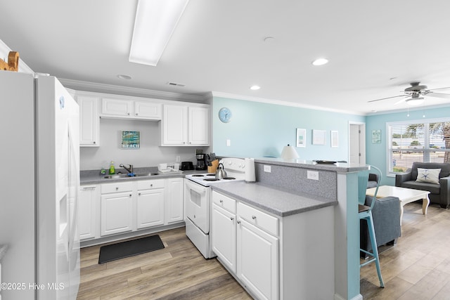 kitchen with sink, white cabinetry, ornamental molding, white appliances, and light hardwood / wood-style floors