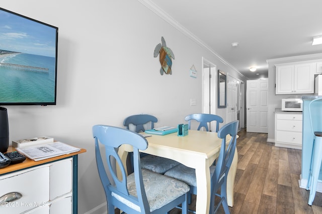 dining space featuring crown molding and dark hardwood / wood-style flooring
