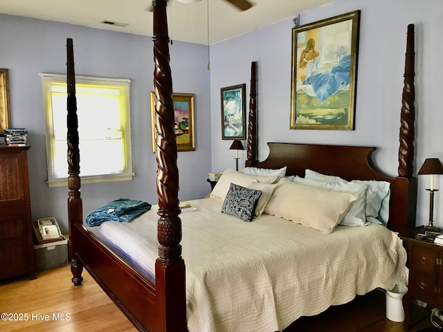 bedroom featuring a ceiling fan, visible vents, and light wood-style flooring