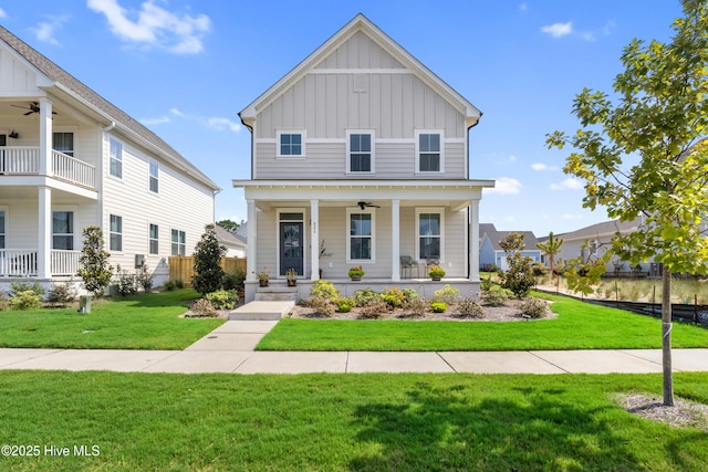 view of front of home featuring ceiling fan, covered porch, and a front yard