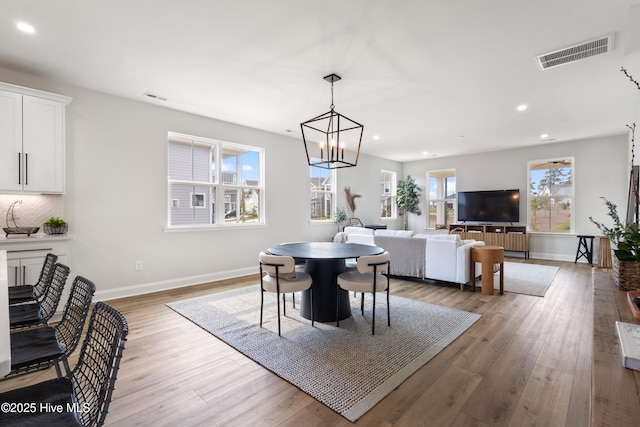 dining room with an inviting chandelier and light wood-type flooring