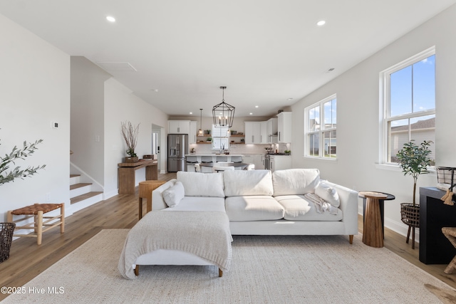 living room featuring wood-type flooring and a notable chandelier