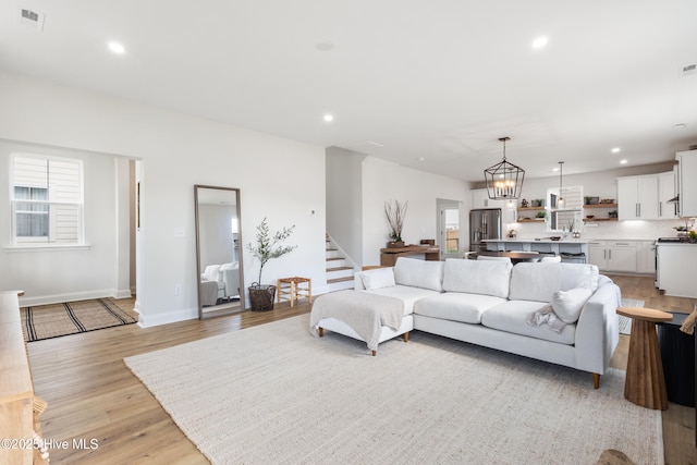 living room featuring light hardwood / wood-style flooring and a notable chandelier