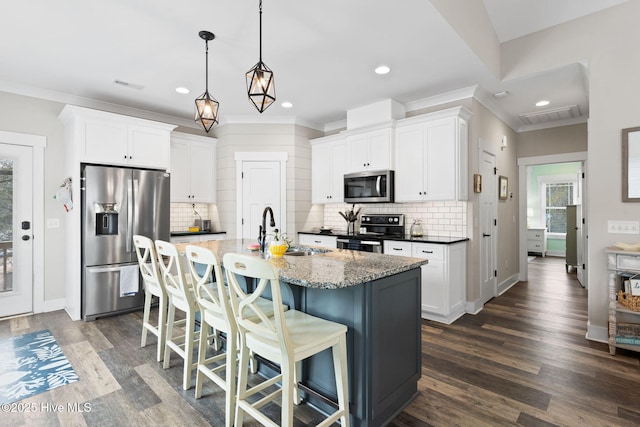 kitchen with white cabinetry, sink, a center island with sink, and appliances with stainless steel finishes