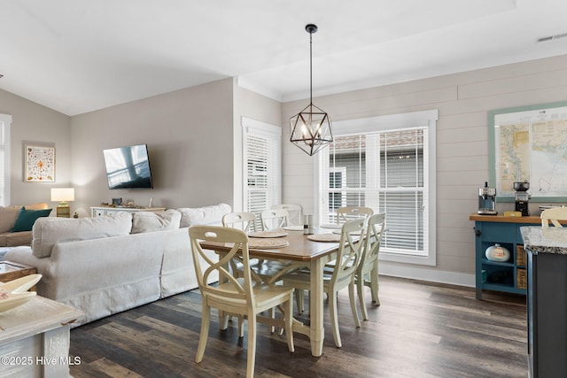 dining room featuring lofted ceiling, dark hardwood / wood-style floors, and a chandelier