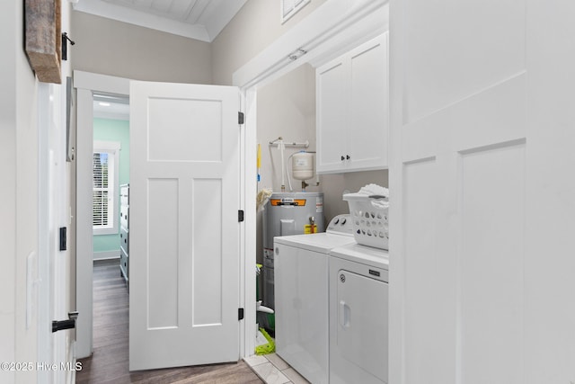 laundry room with cabinets, washer and clothes dryer, light hardwood / wood-style floors, and water heater