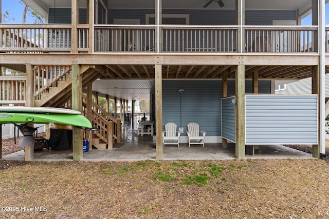 rear view of house featuring a wooden deck and a patio area