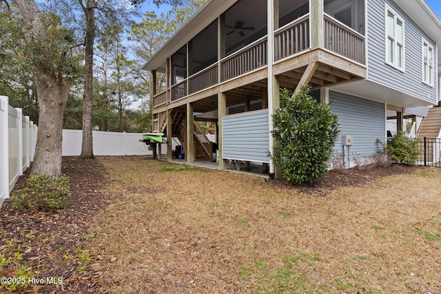 back of house featuring a sunroom and ceiling fan