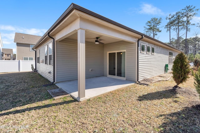 back of property featuring ceiling fan, a yard, and a patio