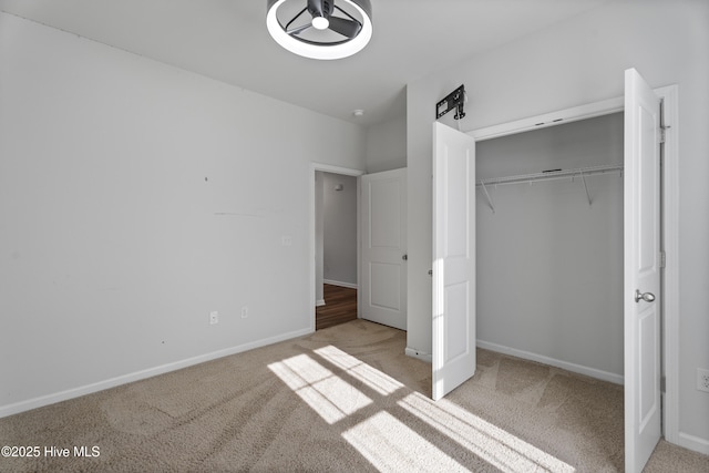 unfurnished bedroom featuring light colored carpet and a closet