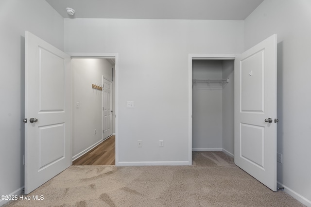 unfurnished bedroom with light carpet and a closet