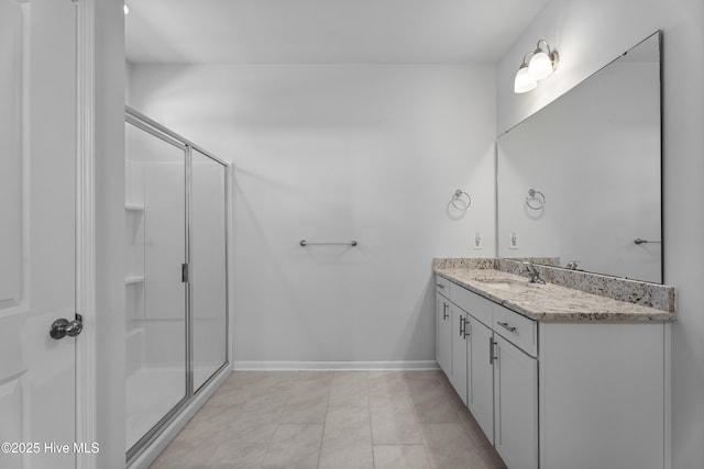 bathroom with tile patterned floors, vanity, and a shower with door