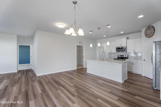 kitchen with sink, white cabinetry, decorative light fixtures, a center island with sink, and stainless steel appliances