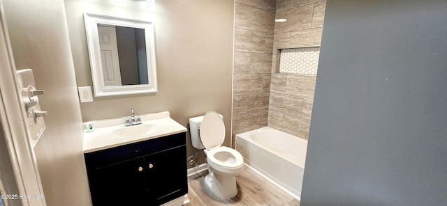 full bathroom featuring hardwood / wood-style flooring, vanity, toilet, and tiled shower / bath combo