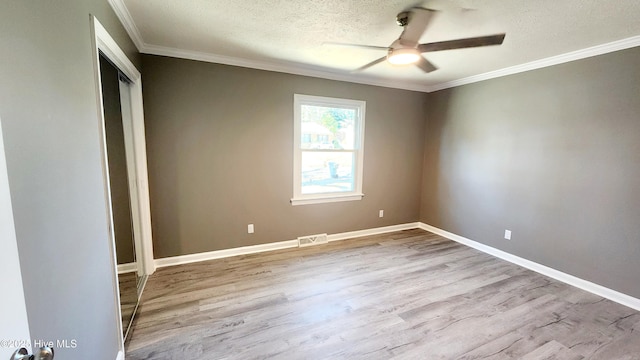 unfurnished room featuring ceiling fan, crown molding, light hardwood / wood-style flooring, and a textured ceiling