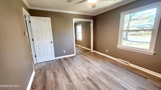 unfurnished bedroom featuring crown molding, ceiling fan, and light wood-type flooring