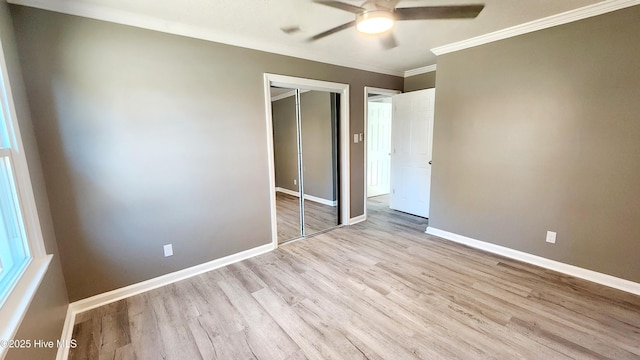 unfurnished bedroom featuring crown molding, light hardwood / wood-style flooring, a closet, and ceiling fan