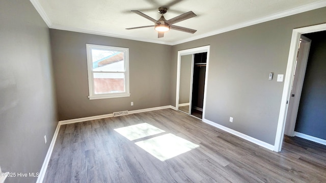 unfurnished bedroom with ornamental molding, light hardwood / wood-style flooring, ceiling fan, and a closet