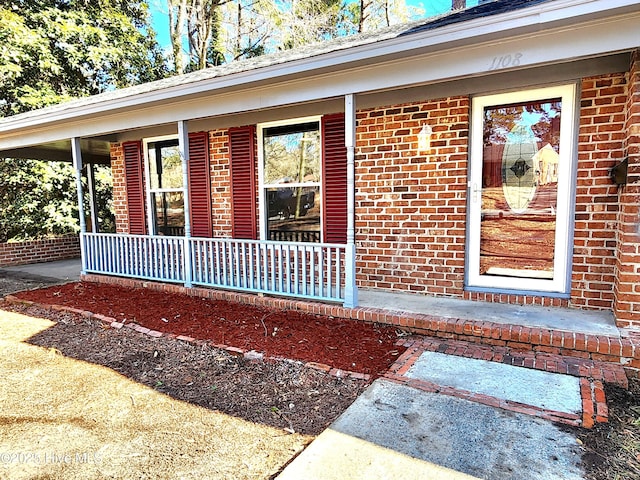 view of exterior entry featuring covered porch