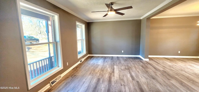 empty room with ceiling fan, light hardwood / wood-style flooring, ornamental molding, and a textured ceiling