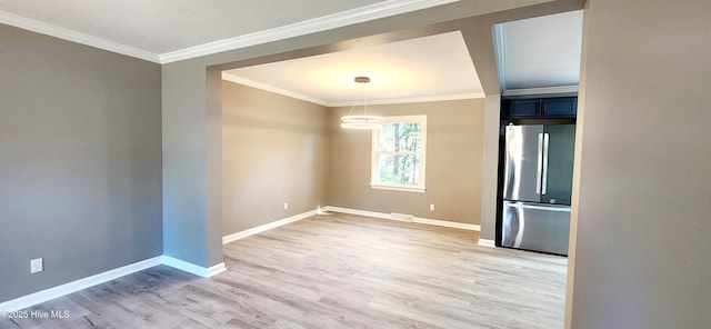 empty room with crown molding and light hardwood / wood-style flooring