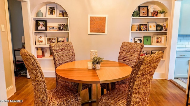 dining area featuring hardwood / wood-style flooring and built in shelves