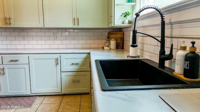 kitchen featuring sink, light tile patterned floors, and decorative backsplash