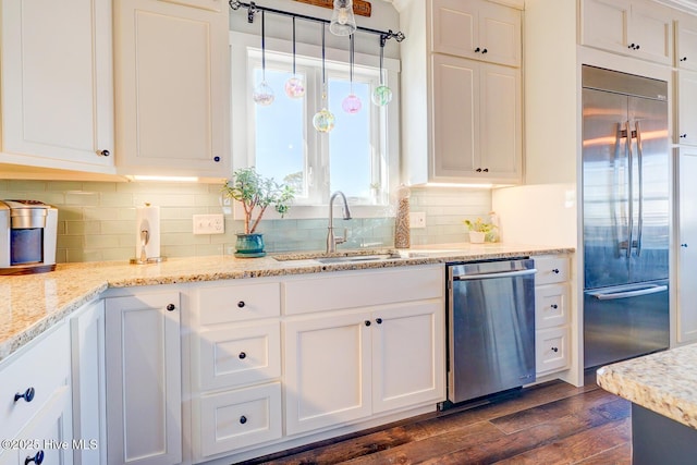 kitchen with white cabinetry, sink, dark hardwood / wood-style flooring, stainless steel appliances, and light stone countertops