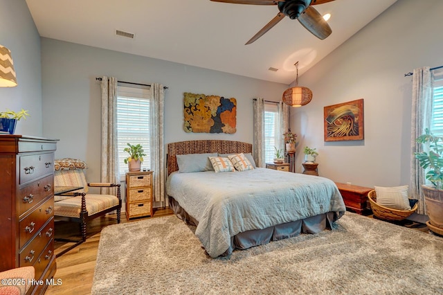 bedroom with ceiling fan, vaulted ceiling, and light hardwood / wood-style flooring