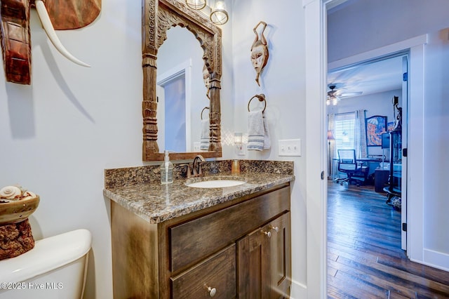 bathroom featuring ceiling fan, vanity, toilet, and wood-type flooring