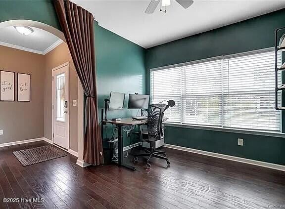 office with arched walkways, ornamental molding, dark wood-style flooring, and baseboards