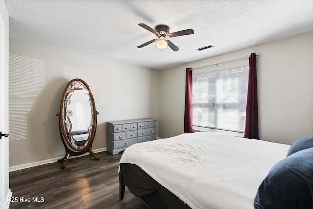 bedroom featuring dark wood-type flooring, a textured ceiling, and ceiling fan