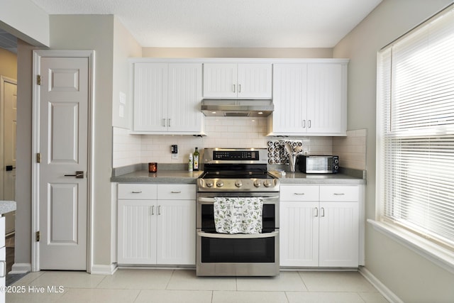 kitchen featuring backsplash, double oven range, light tile patterned floors, and white cabinets