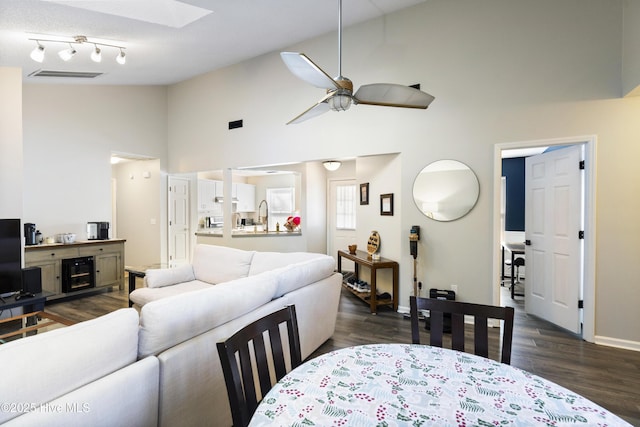 living room with ceiling fan, high vaulted ceiling, and dark hardwood / wood-style flooring