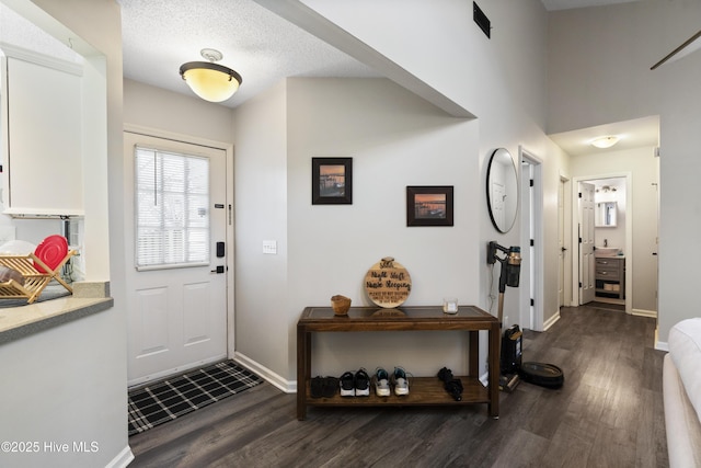 entrance foyer with dark hardwood / wood-style floors and a textured ceiling