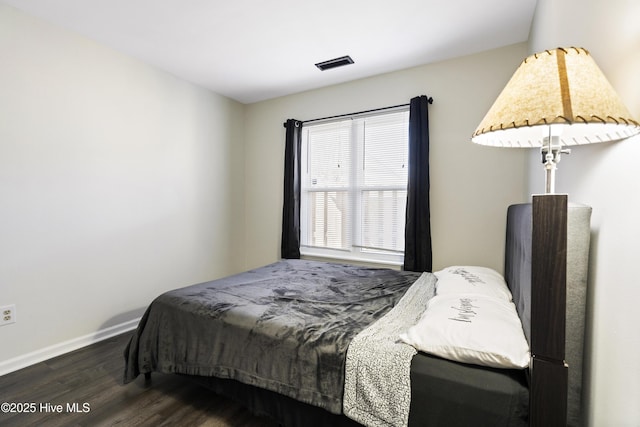 bedroom with dark hardwood / wood-style floors