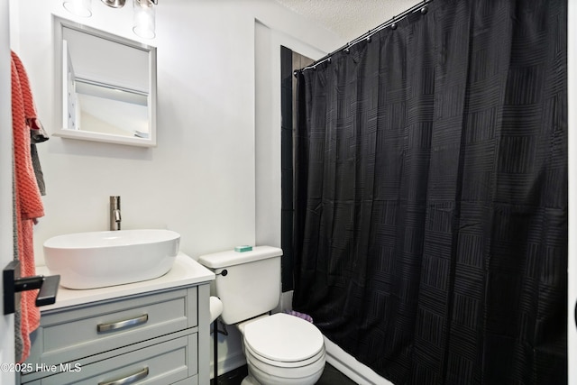 bathroom featuring vanity, walk in shower, and toilet