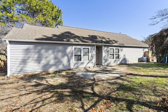 back of property with a patio and a yard