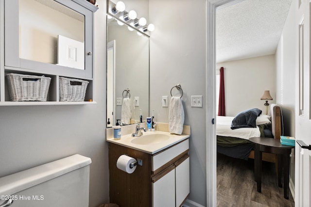 bathroom with vanity, hardwood / wood-style floors, toilet, and a textured ceiling