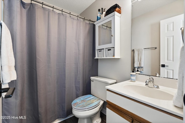 bathroom featuring vanity, toilet, and a textured ceiling