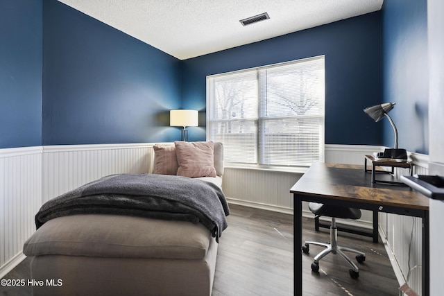 bedroom featuring wood-type flooring and a textured ceiling