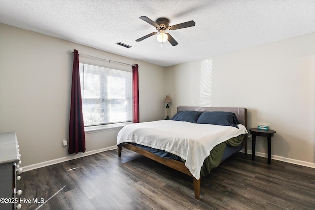 bedroom featuring dark wood-type flooring, ceiling fan, and a textured ceiling