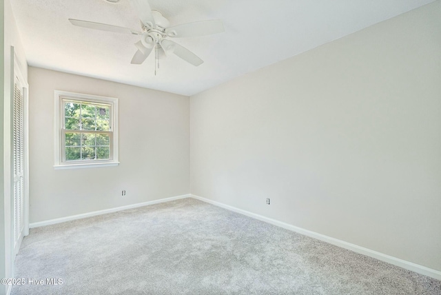 carpeted spare room featuring ceiling fan