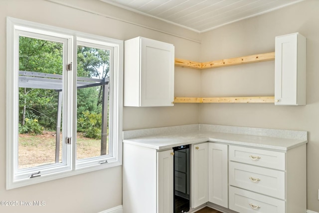 kitchen featuring beverage cooler and white cabinets