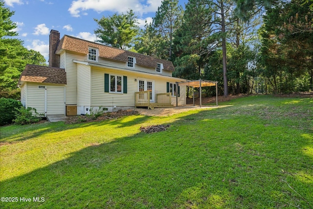 rear view of house with a deck and a lawn