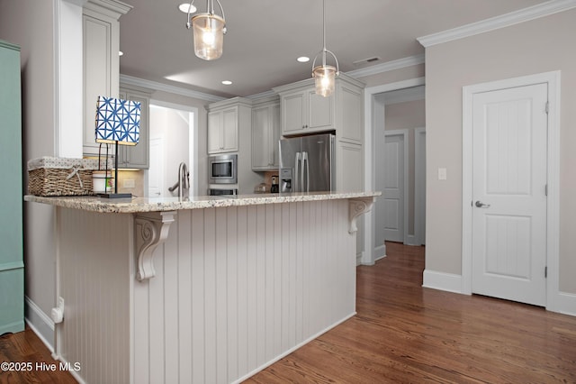 kitchen featuring light stone counters, dark wood finished floors, a peninsula, ornamental molding, and stainless steel appliances